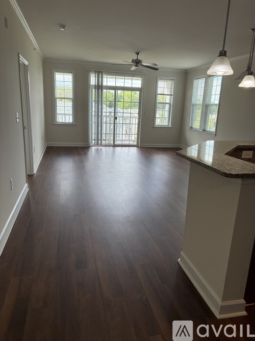 A spacious room with wooden floors and a large window.