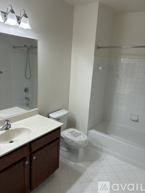 A white bathroom with a toilet, sink, and bathtub.