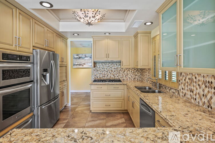 A kitchen with wooden cabinets and granite countertops.