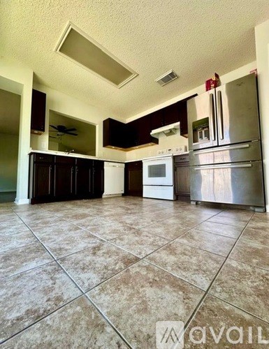 A kitchen with tile flooring and stainless steel appliances.