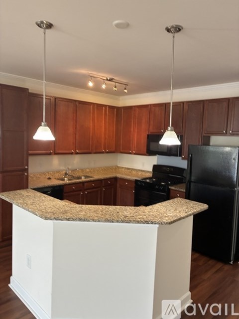 A kitchen with brown cabinets and a granite counter.
