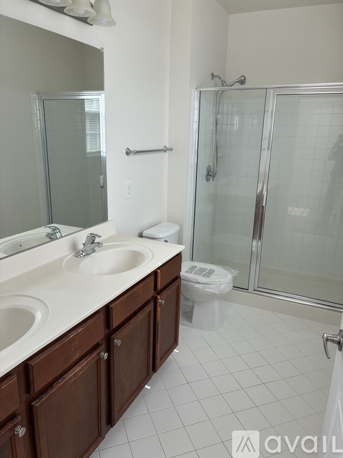 A bathroom with a glass shower door and a white sink.