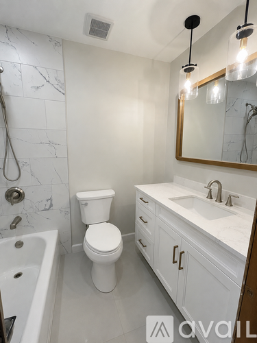 A white bathroom with a toilet, sink, and tub.