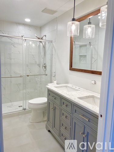 A bathroom with a toilet, sink, and shower.