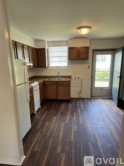 A kitchen with white appliances and wooden cabinets.