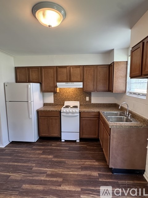 A kitchen with brown cabinets and a white fridge.