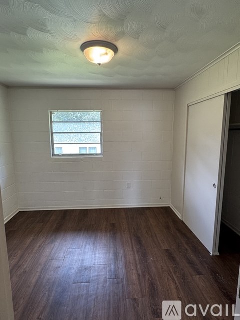 A room with a window and wooden floors.