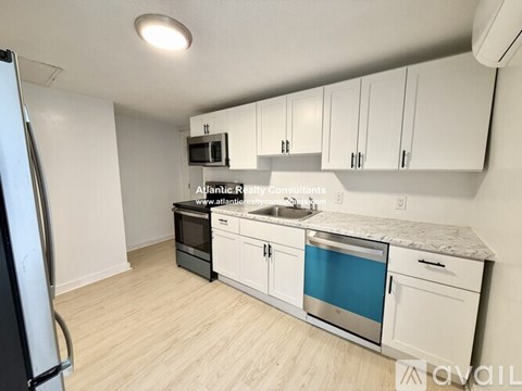 A kitchen with white cabinets and a blue dishwasher.