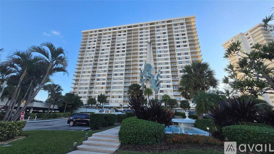 A tall building with a pool in front of it.