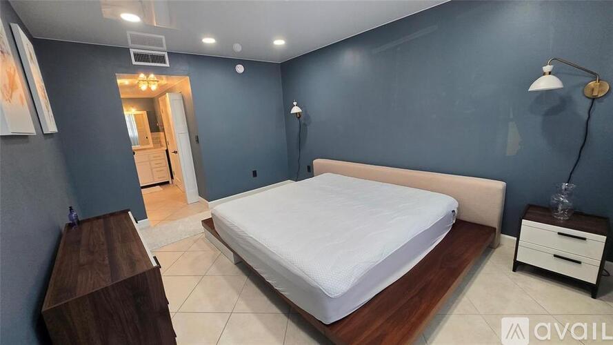 A bedroom with a bed, nightstand, and lamp.