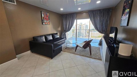 A living room with a black sofa and a brown chair.
