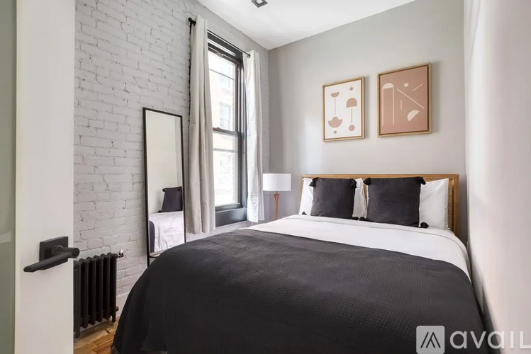 A bedroom with a large bed and a white brick wall.