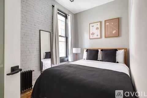 A bedroom with a large bed and a white brick wall.