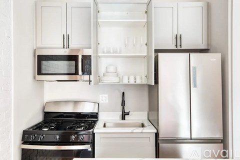A kitchen with white cabinets and appliances.