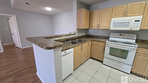 A kitchen with wooden cabinets and a granite countertop.