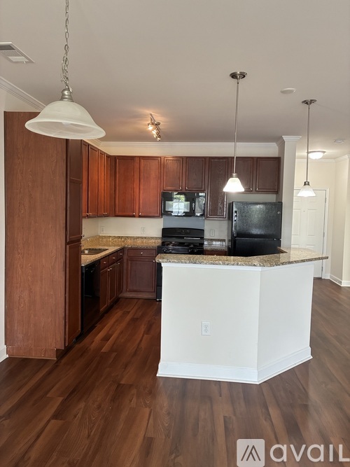 A kitchen with wooden cabinets and a white island.