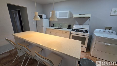 A kitchen with a table and chairs in front of a stove and oven.