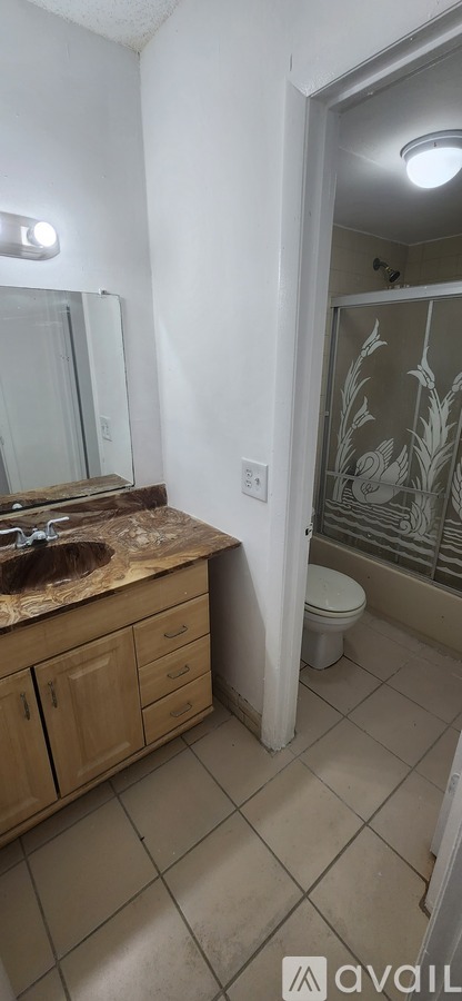 A bathroom with a sink, mirror, and toilet.