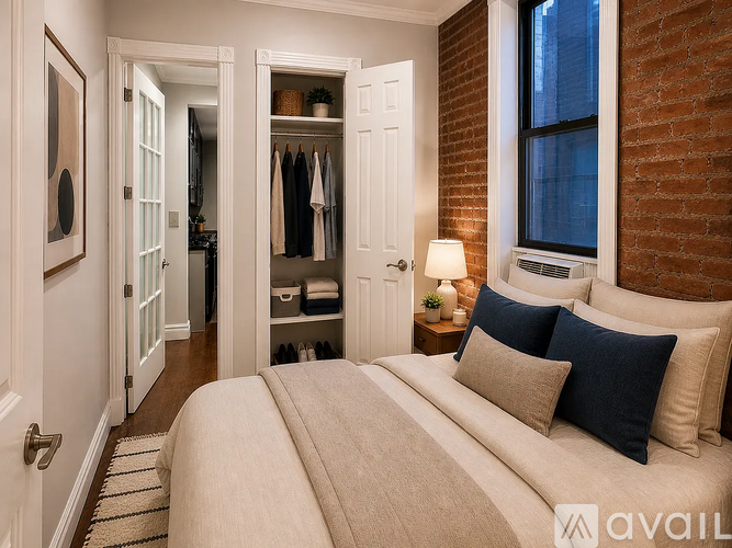 A bedroom with a large bed and a brick wall.