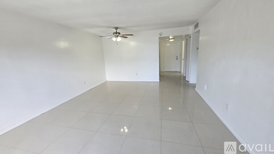A spacious room with a ceiling fan and tiled flooring.