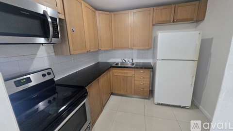 A kitchen with wooden cabinets and a white refrigerator.