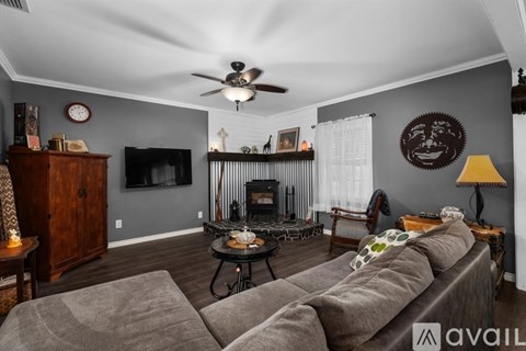 A living room with a grey couch and a fireplace.