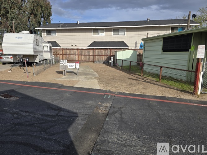 A parking lot with a trailer and a building in the background.