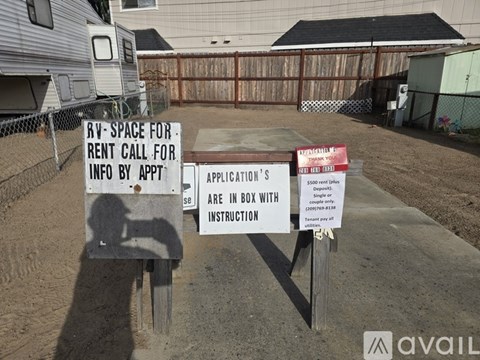 A sign in front of a fence advertises an RV space for rent.