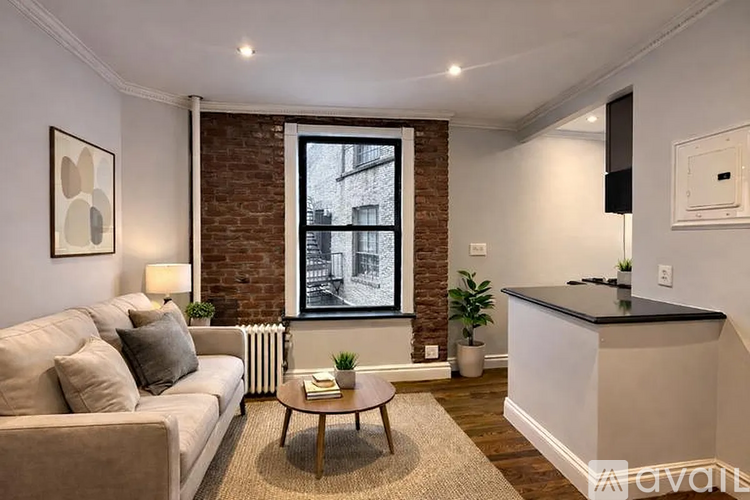 A living room with a couch, a coffee table, and a window.