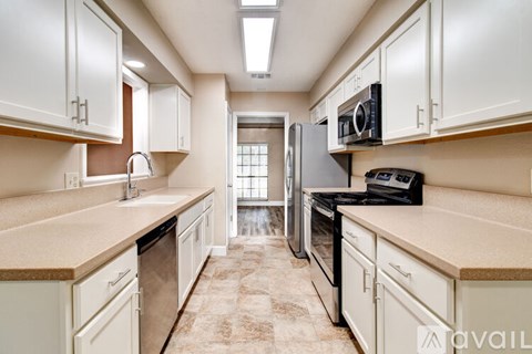 A kitchen with white cabinets and appliances.