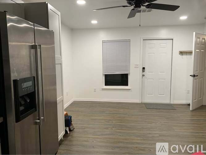 A kitchen with a stainless steel refrigerator and a ceiling fan.