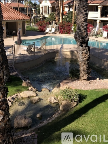 A pool with a waterfall and rocks in the foreground.