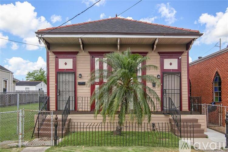 A house with a red door and a palm tree in front.