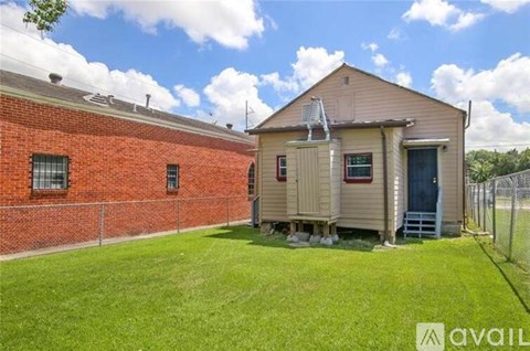 A red brick building with a small house in front of it.