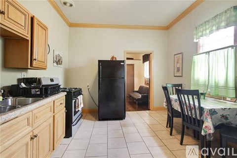 A kitchen with wooden cabinets and a black refrigerator.