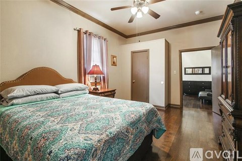 A bedroom with a bed covered in a blue and green patterned bedspread.