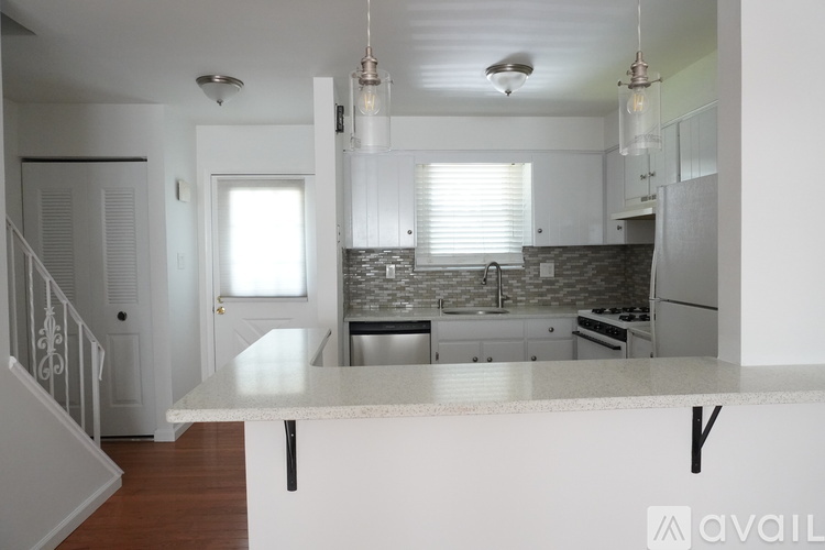A kitchen with a white countertop and stainless steel appliances.