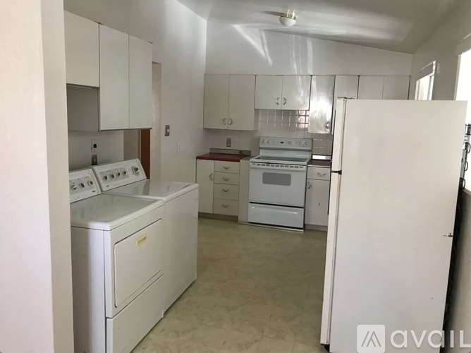 A kitchen with white appliances and cabinets.