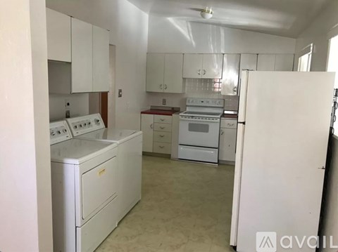 A kitchen with white appliances and cabinets.