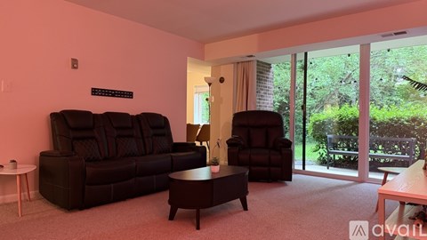 A living room with a black sofa and a black armchair.
