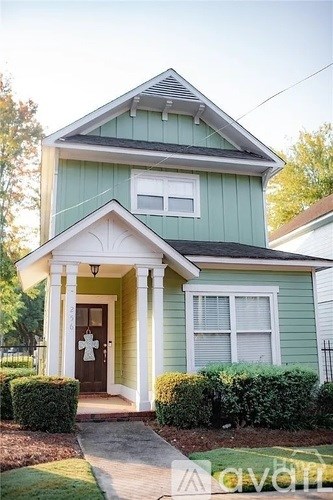 A small house with a front porch and a brown door.