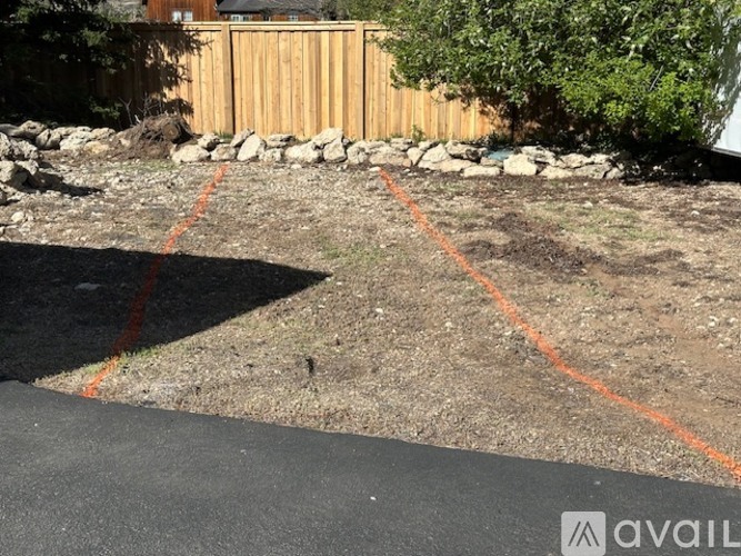 A backyard with a wooden fence and a stone wall.