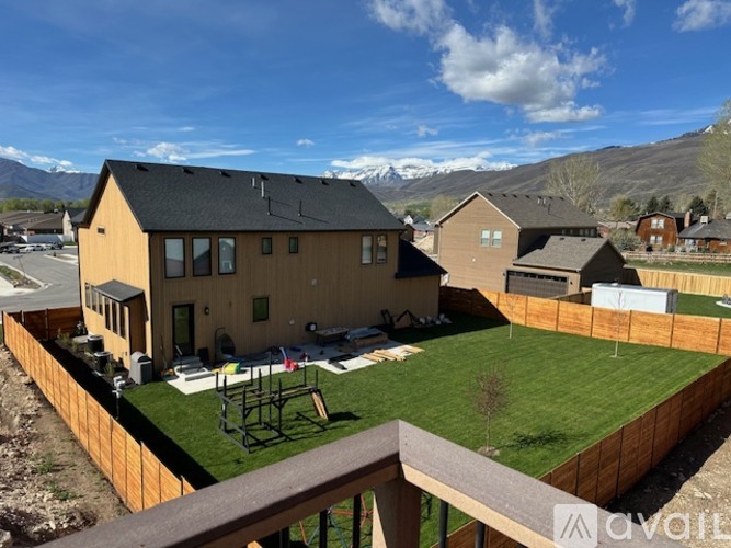 A house with a backyard and a mountain in the background.