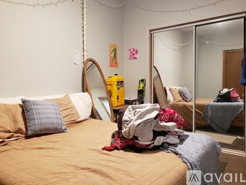 A bedroom with a bed, a mirror, and a wall hanging.