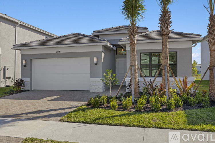 A house with a garage and palm trees in front.