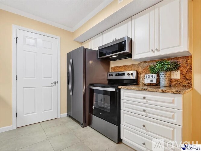 A kitchen with a black refrigerator, microwave, and oven.