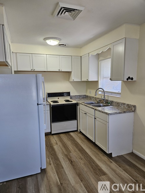 A kitchen with white appliances and cabinets.