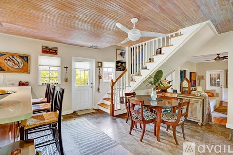 A dining room with a wooden table and chairs.