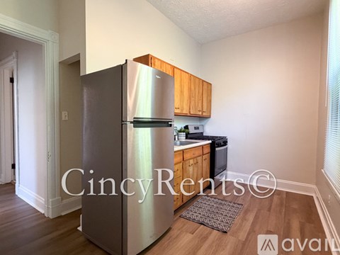 A kitchen with a stainless steel refrigerator and wooden cabinets.