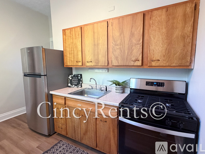 A kitchen with wooden cabinets and a stainless steel refrigerator.